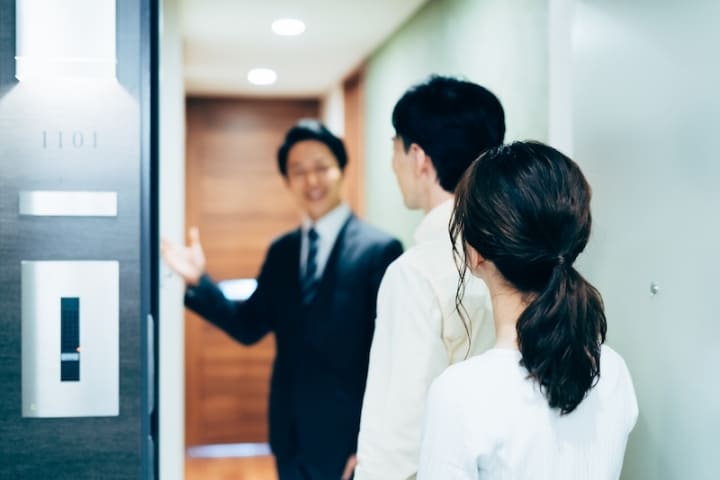 内見予約を表現する、不動産営業がカップルを案内する様子