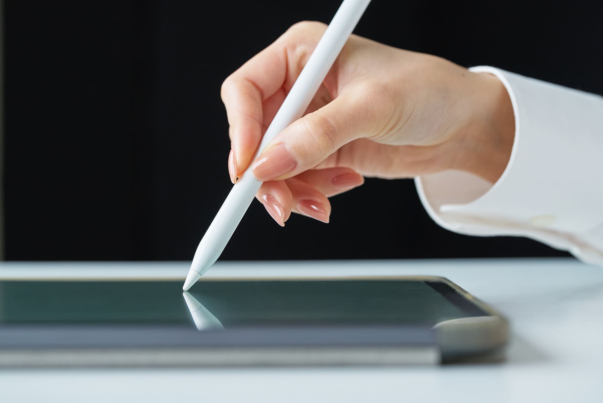 IT重説・電子契約をイメージする、タブレットに書く手