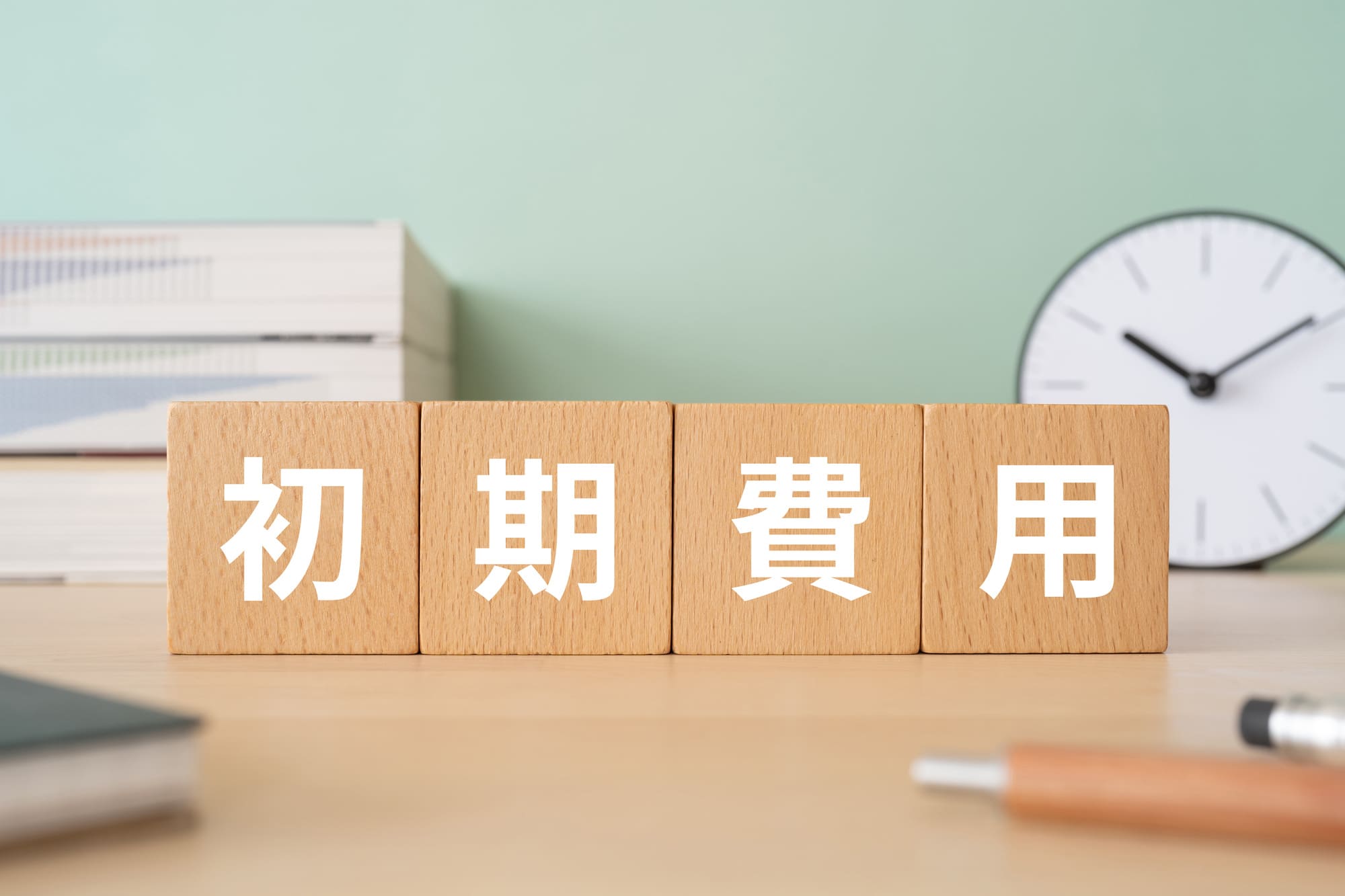 初期費用の分割払いをイメージする、木製ブロックと書類が置かれた机